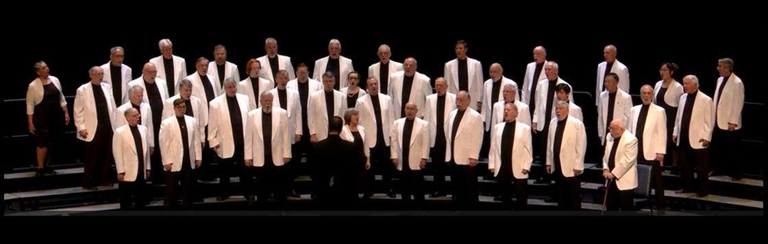 The Fairfax Jubil-Aires chorus on stage in white jackets